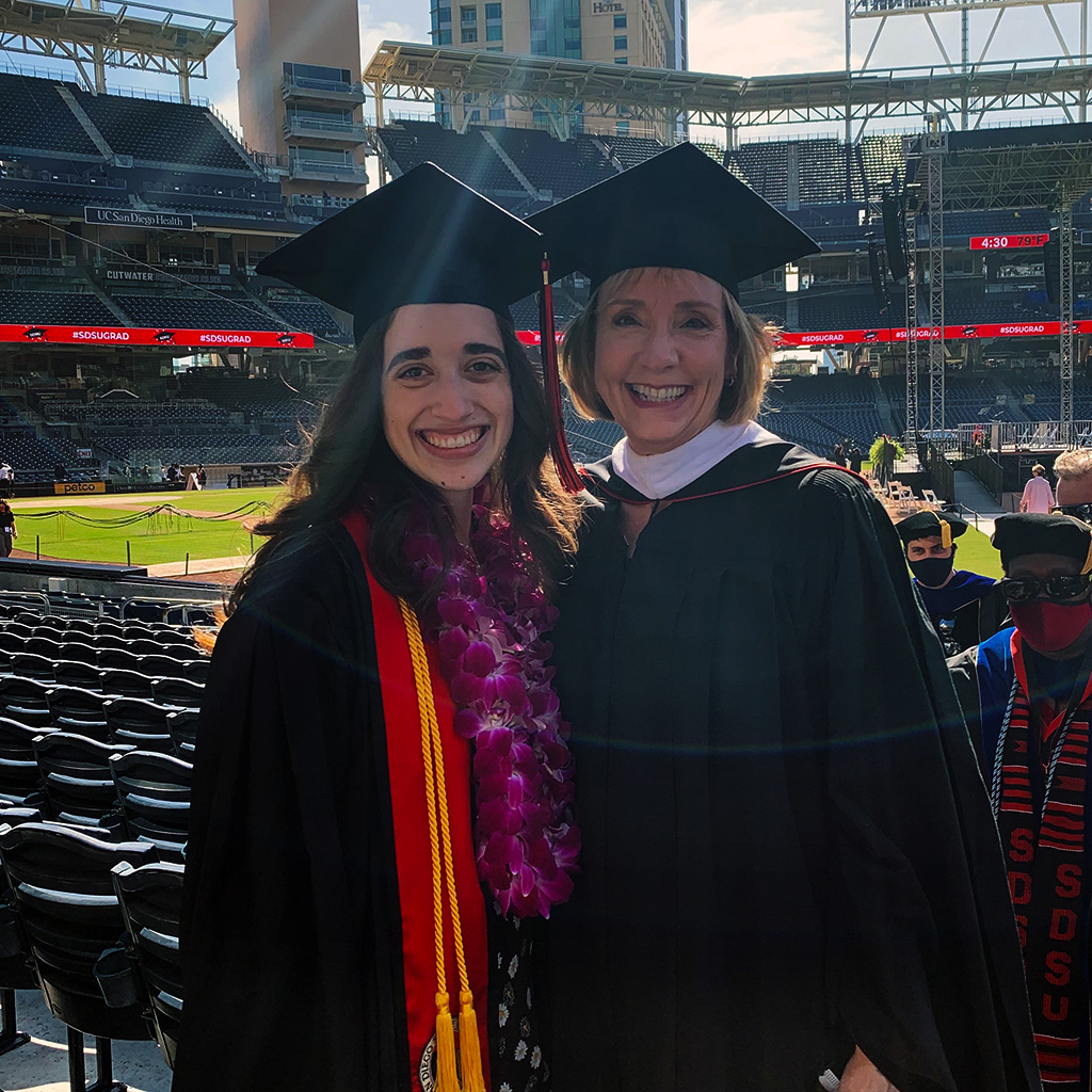 Samantha Quiroz with Patty Kraft both dressed in regalia at Petco Park.
